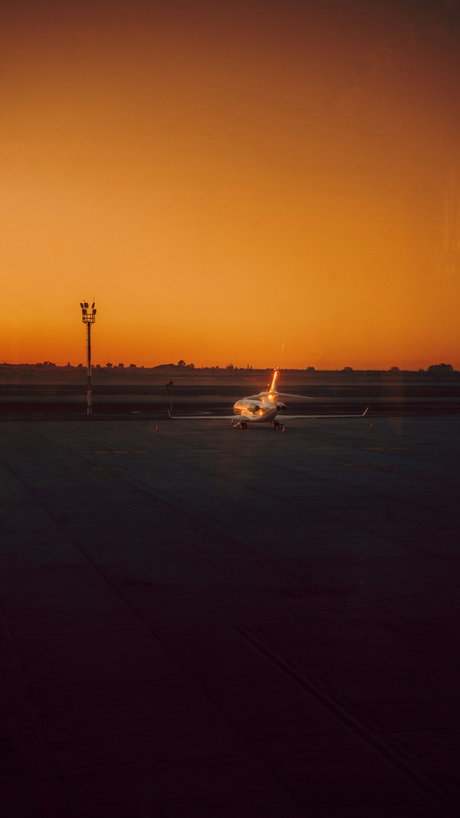Private jet on a runway under a luminous morning sky